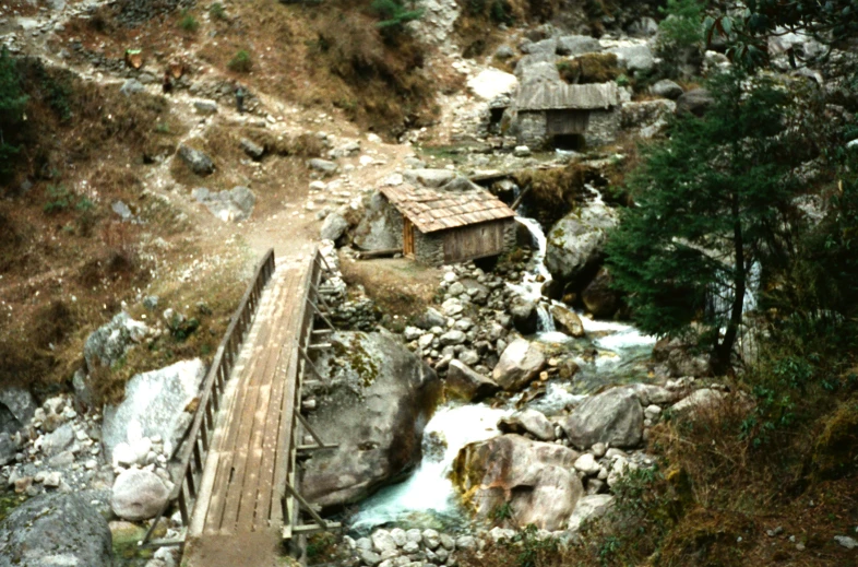 a bridge crosses over rocks near a stream