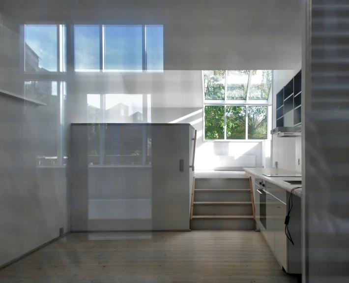 a room with light streaming through the windows and a staircase