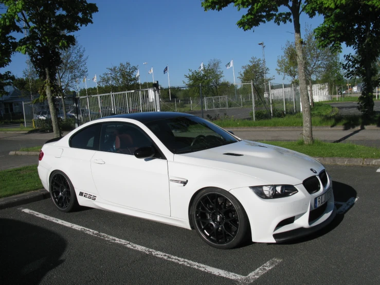 a white sports car is parked in a parking lot