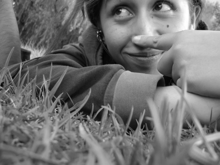 a young woman laying on the grass in the shade