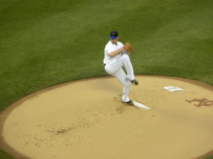 a baseball player throwing a pitch from a mound