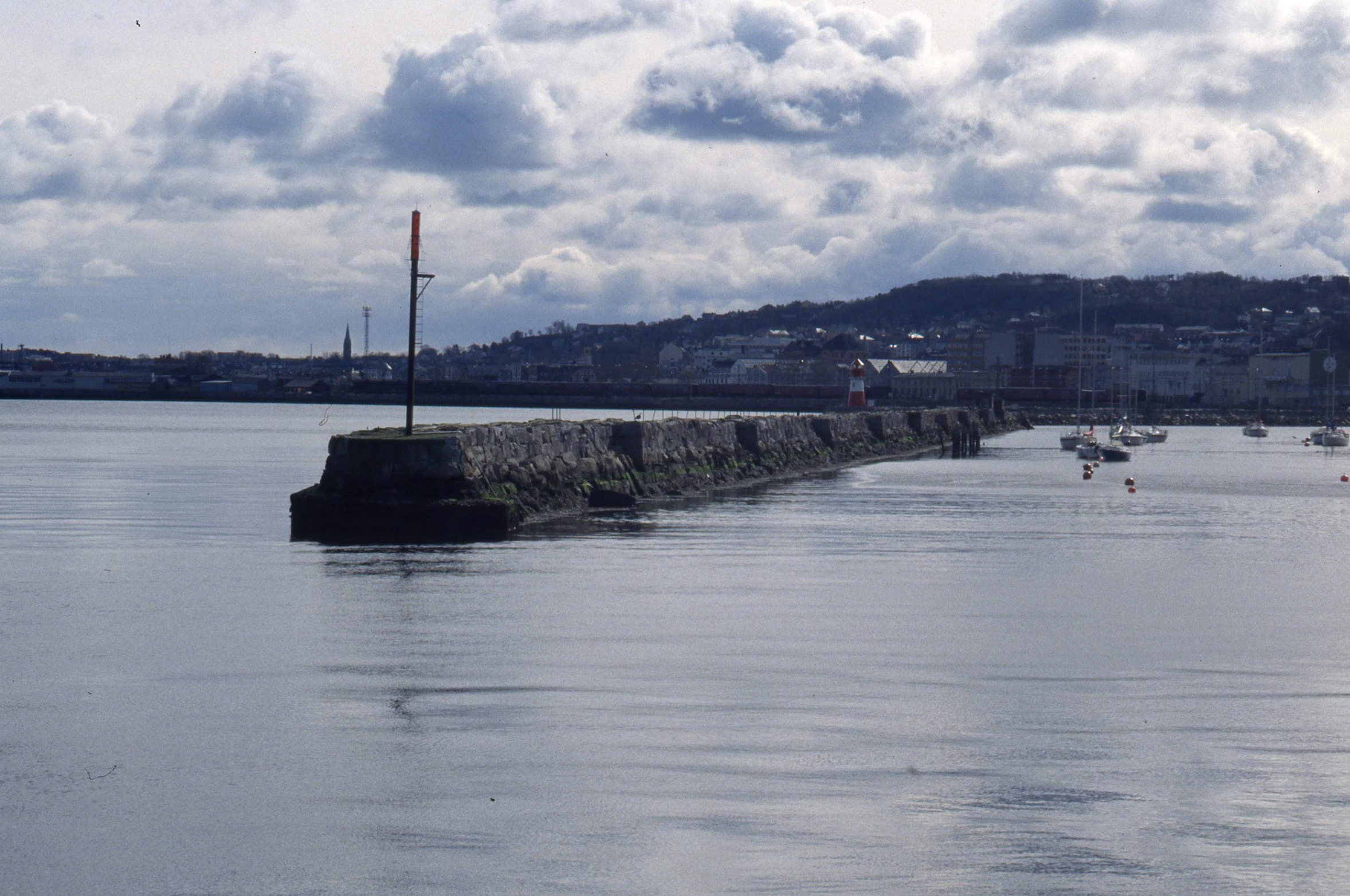 the boats are traveling down the lake by the city