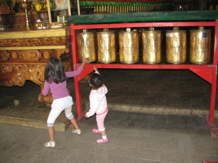 two s reaching for bells on a shelf