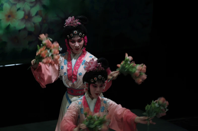 two people standing with flowers in their hands