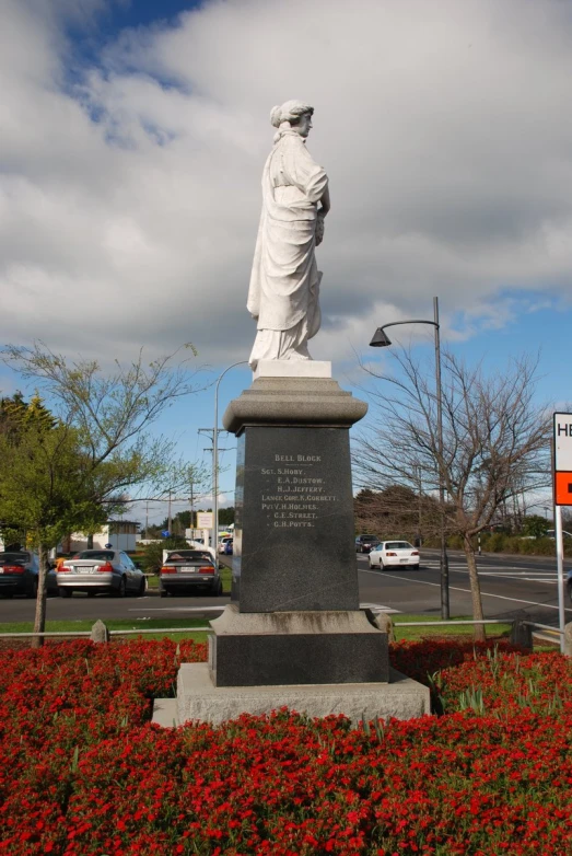 a statue in the center of a flower bed