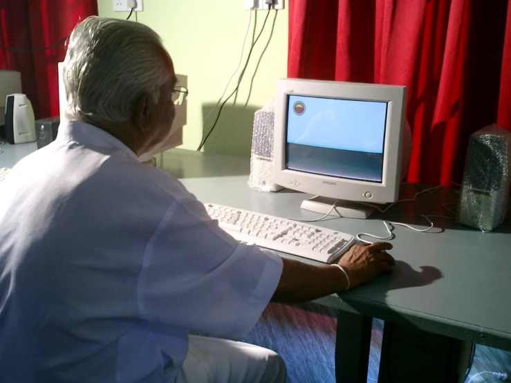 a man looking at the television on his desktop