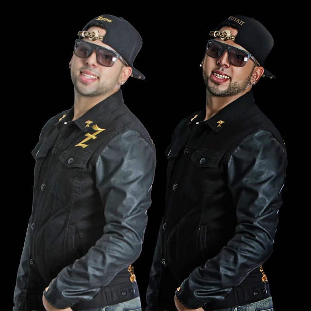 two male singers pose with dark colored outfits and black caps