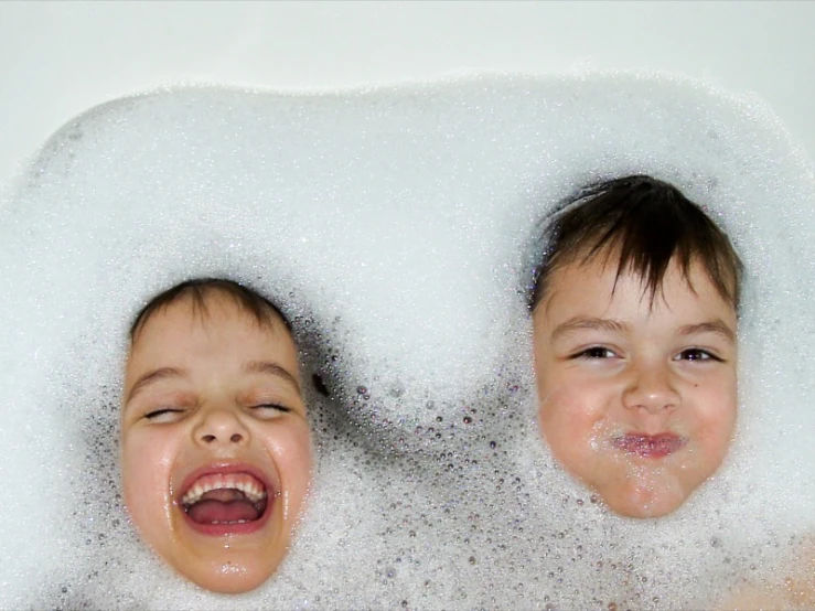 two s are playing in a bubble bath together
