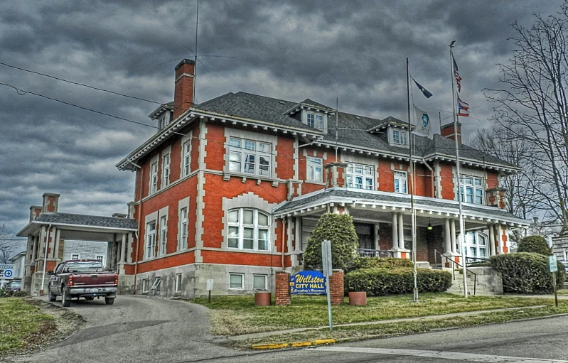 an old brick building sitting across the street from a building on a cloudy day