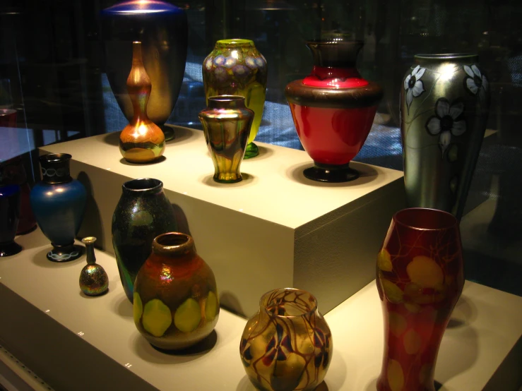 many different colored vases sitting on display