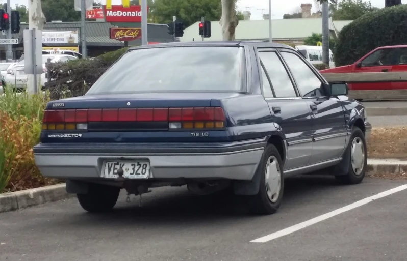 a car parked in a parking space next to some plants