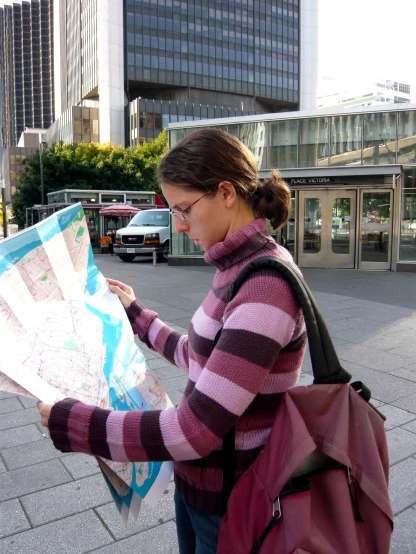 a woman is holding a map and looking at it