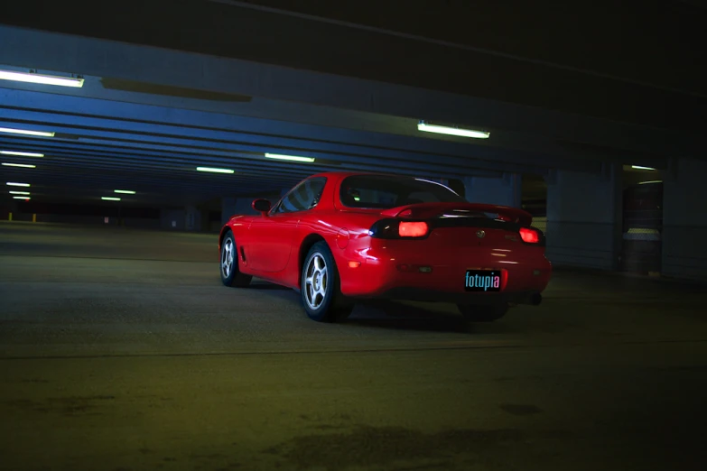 a red sports car is parked in a parking garage