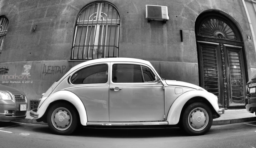 an old car is parked in front of an arched window