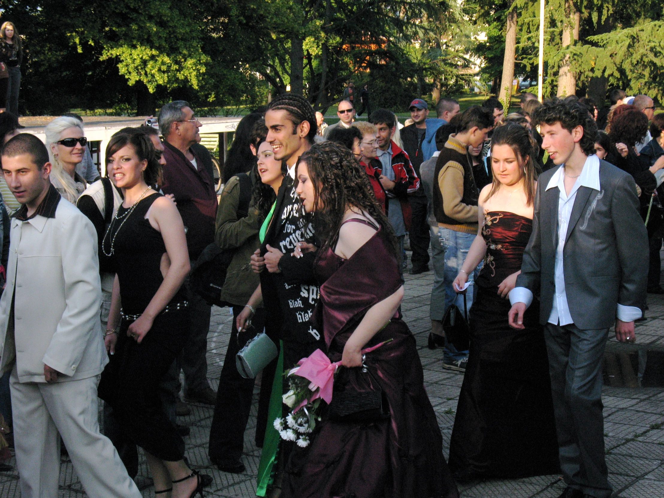 a couple wearing formal wear as a crowd of people