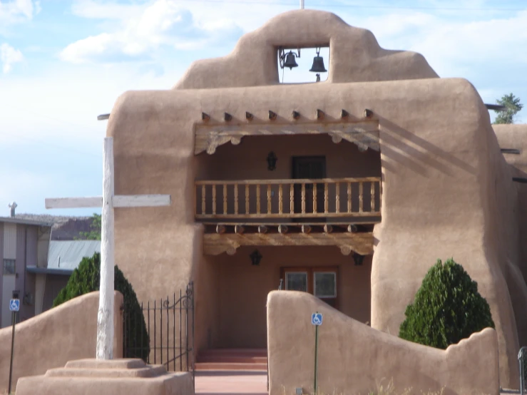 the adobe style building has a small balcony over it