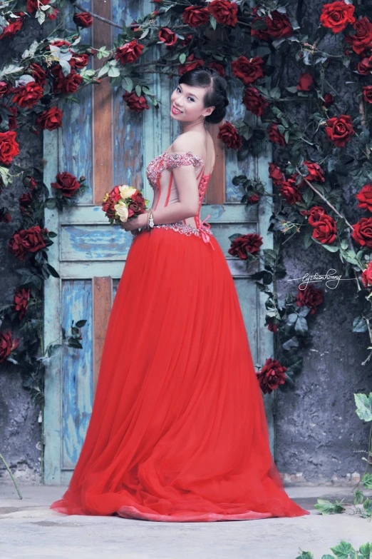 a young woman is standing in front of a door surrounded with roses