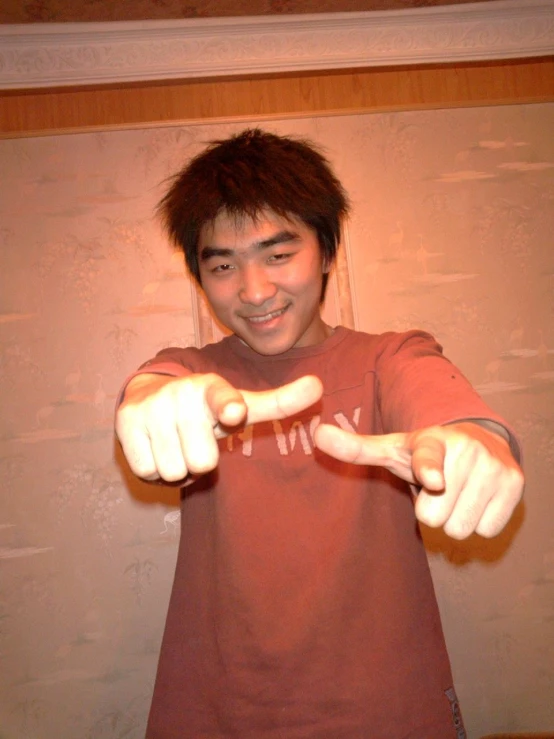 a young man showing off his fingers with a smile on his face