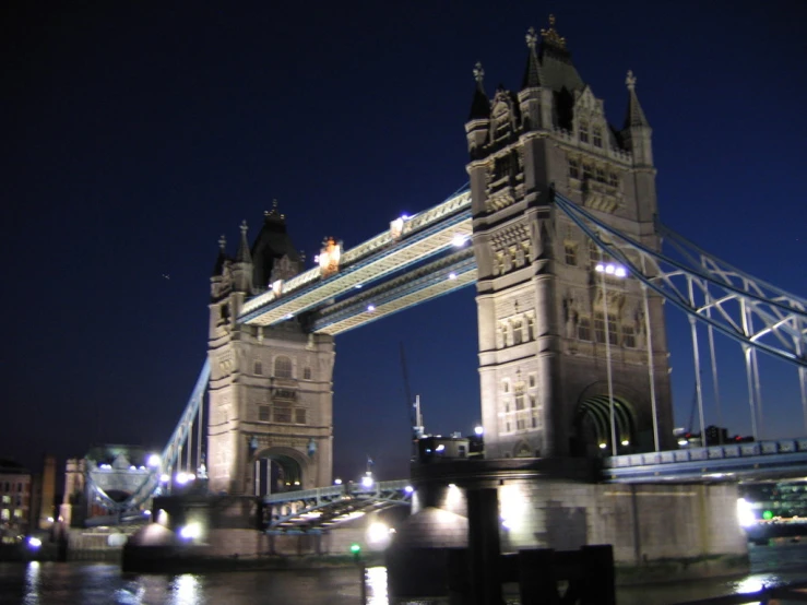 an illuminated bridge over water at night in london