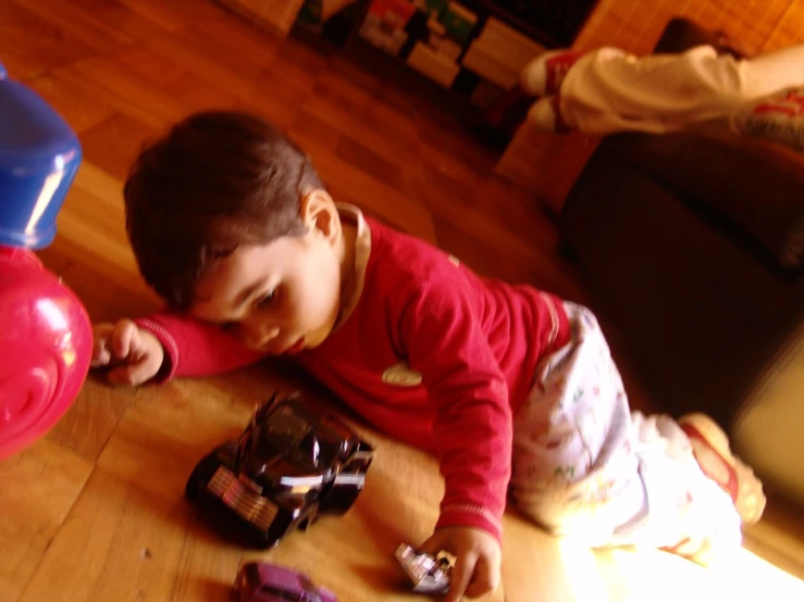 a little  is playing with toy cars