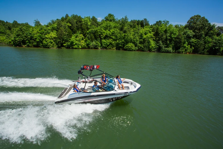 the jet ski boat has three passengers on it