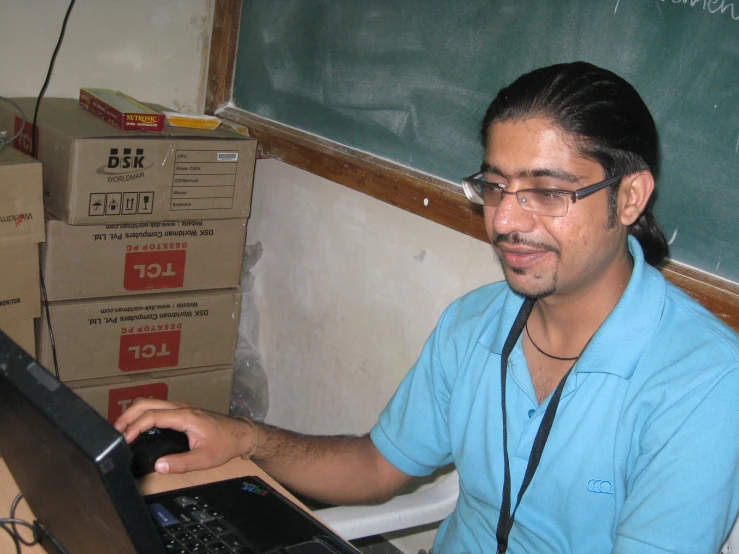 a man sitting at a desk using his laptop