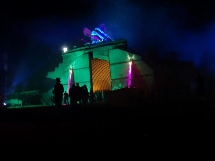 several people standing in front of a colorful tent