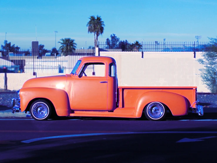 an orange truck is parked in front of the white building