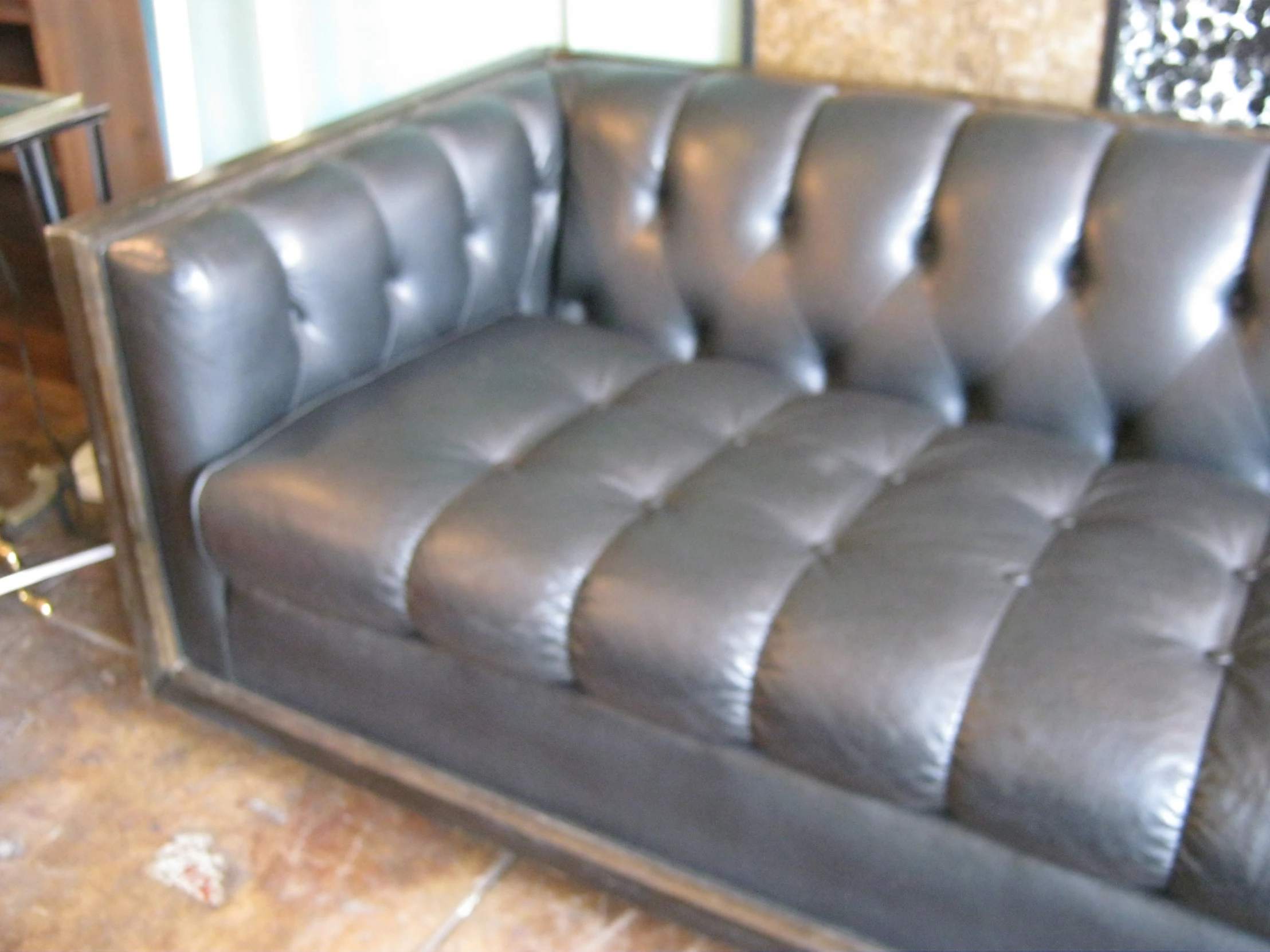 leather couch in front of metal table with vases