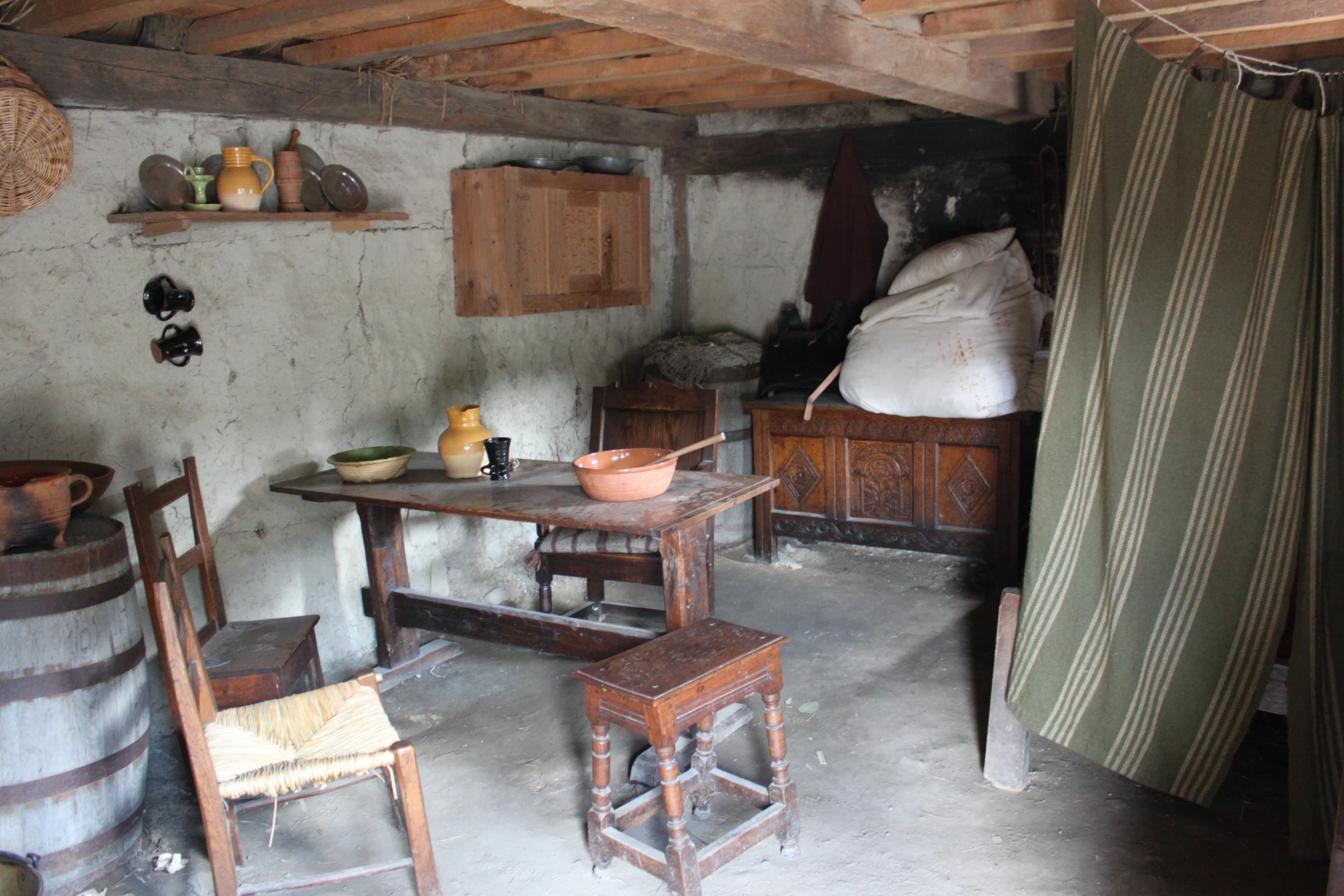 a primitive kitchen with several wooden stools