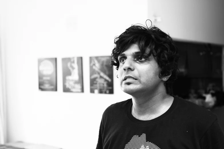 a young man is staring at soing while wearing a t - shirt