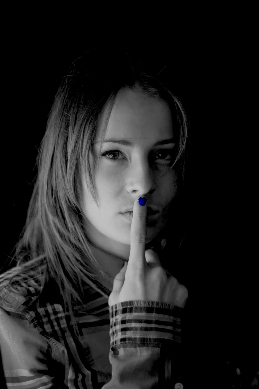 a black and white po of a woman posing with a finger to her lips
