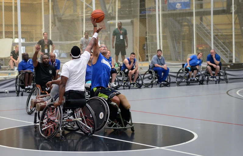 a group of men in wheelchairs playing basketball