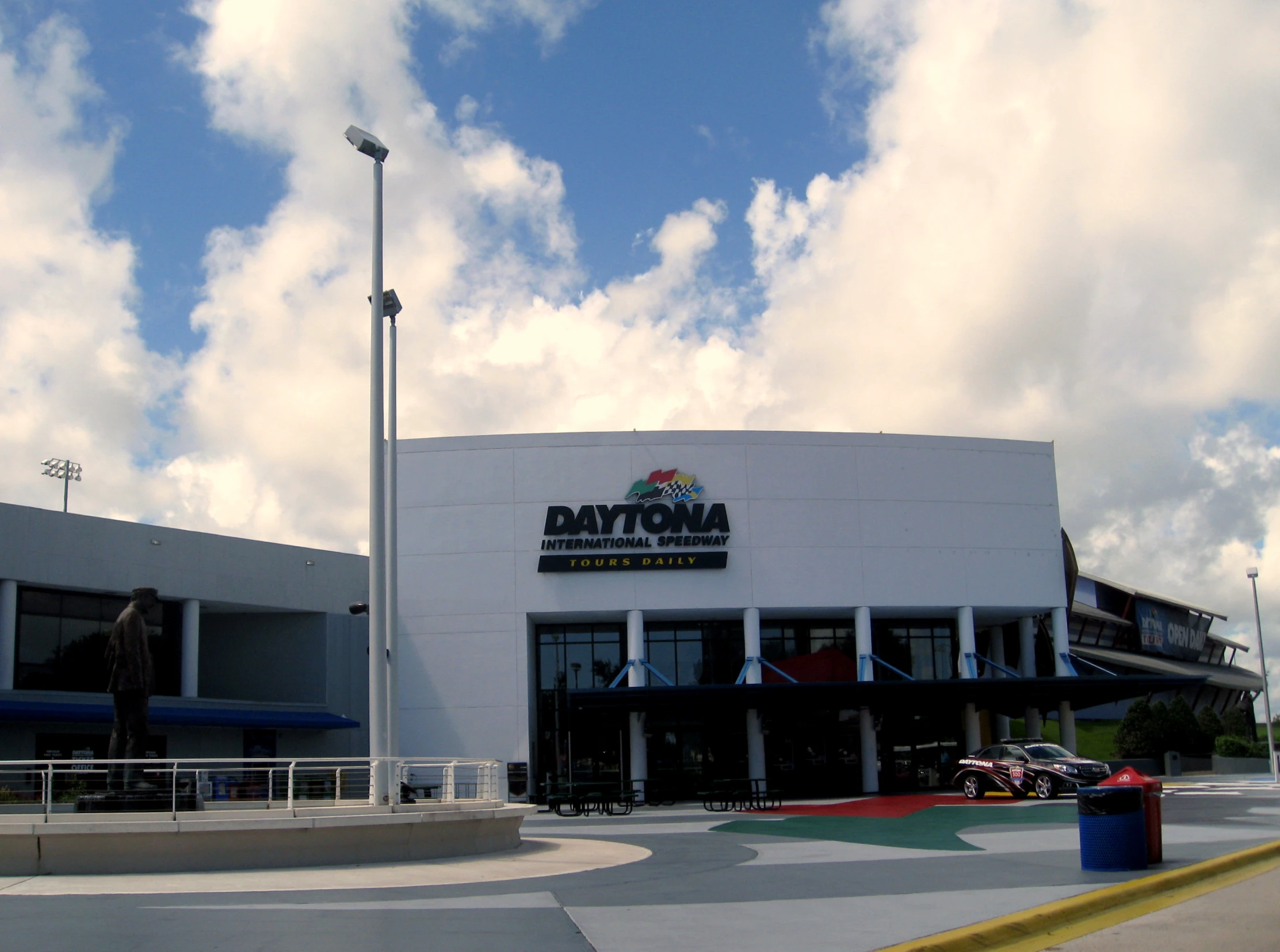 the entrance to a sports complex with a cloudy blue sky