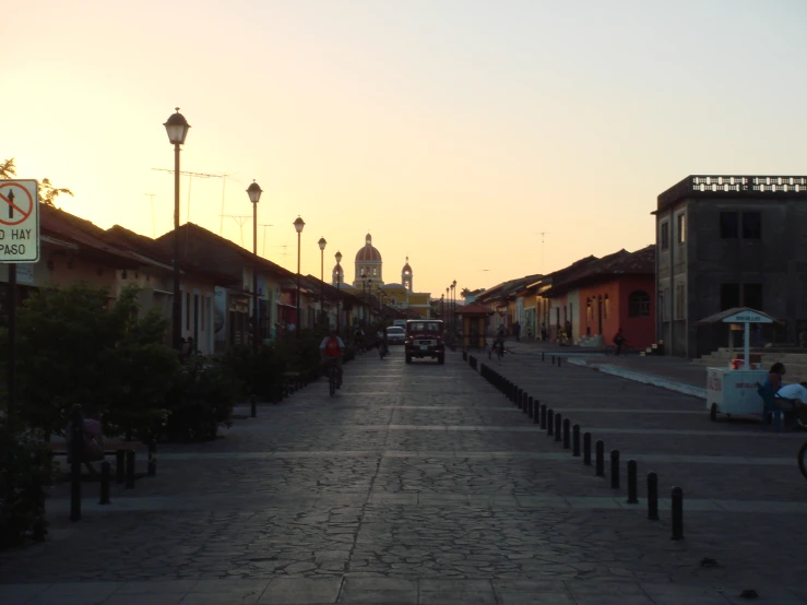 a street with some parked cars and two people