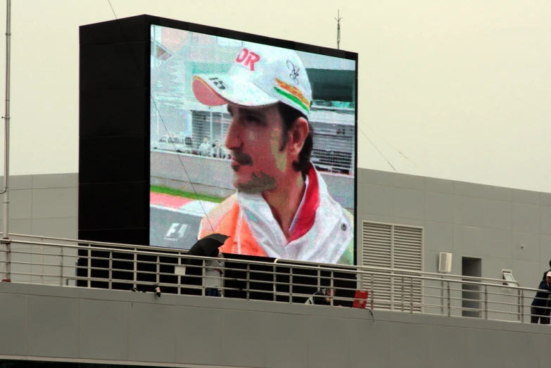 a man on a boat looks at a large video screen