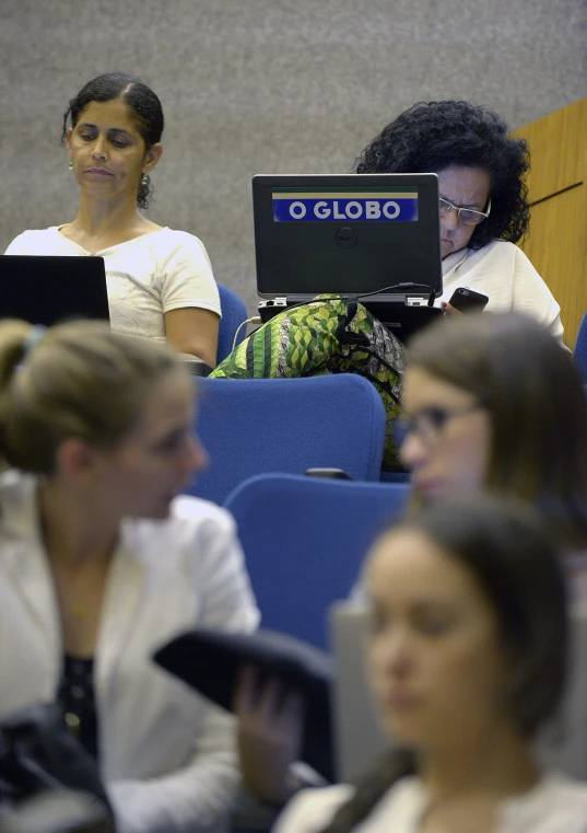 people are listening to a lecture in front of laptops