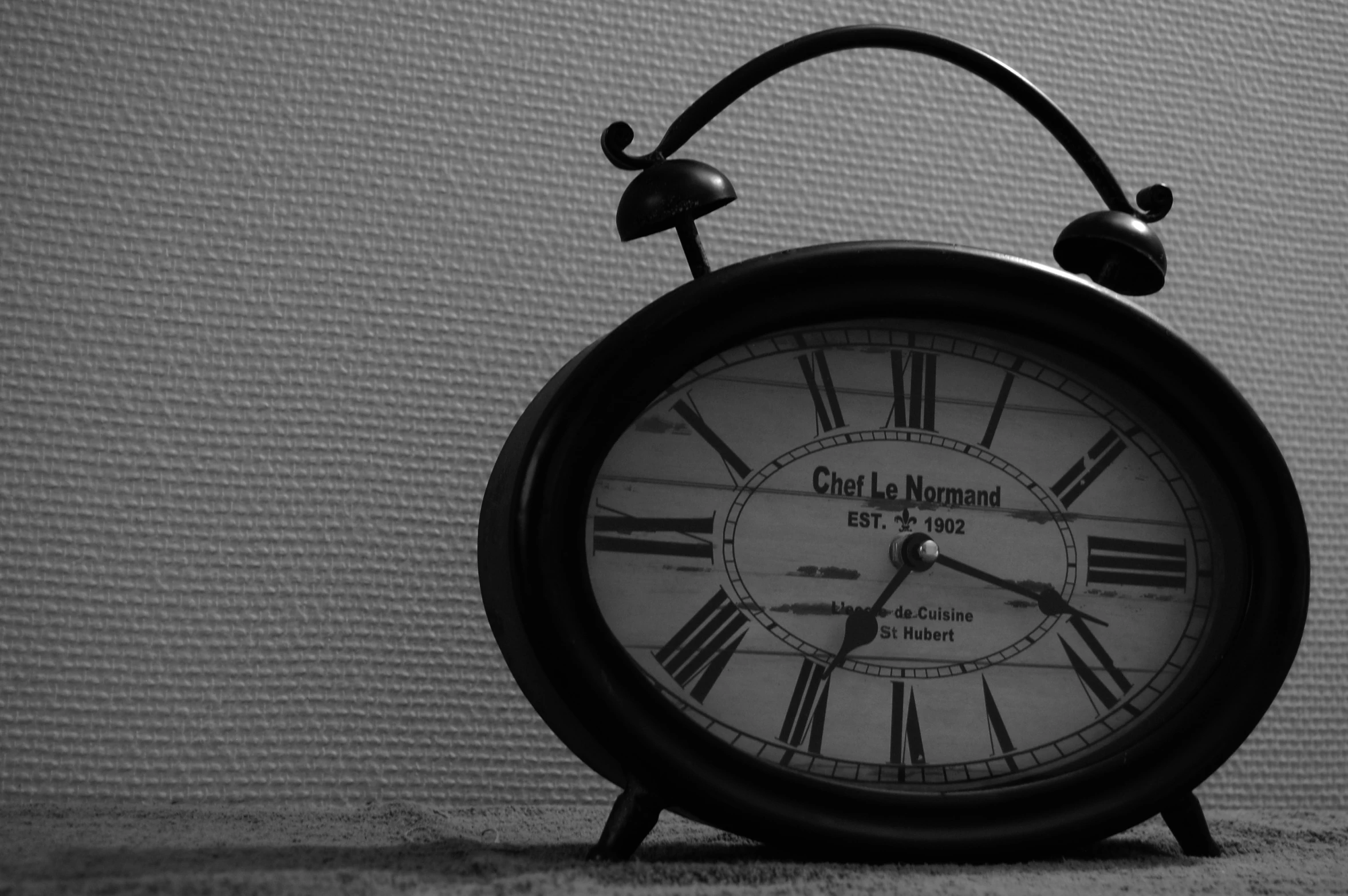 an old, round clock stands next to a wall