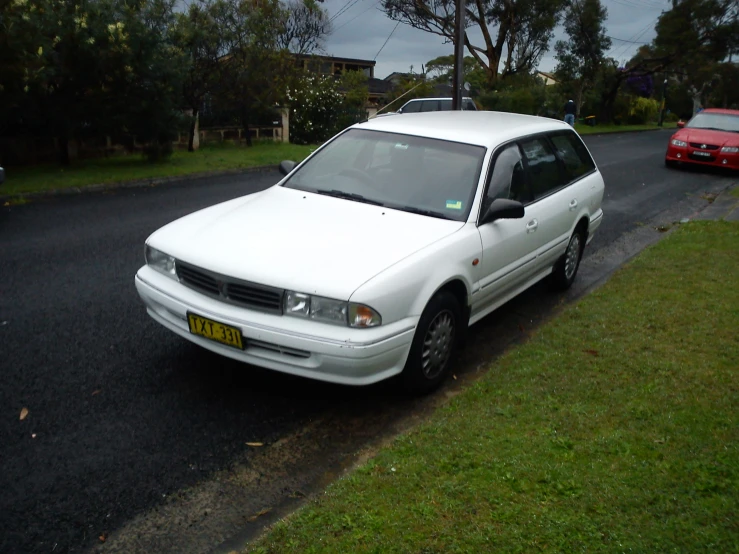 a white car parked on the side of a road