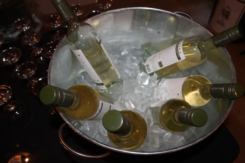 four bottles and six glasses are placed on an ice tray