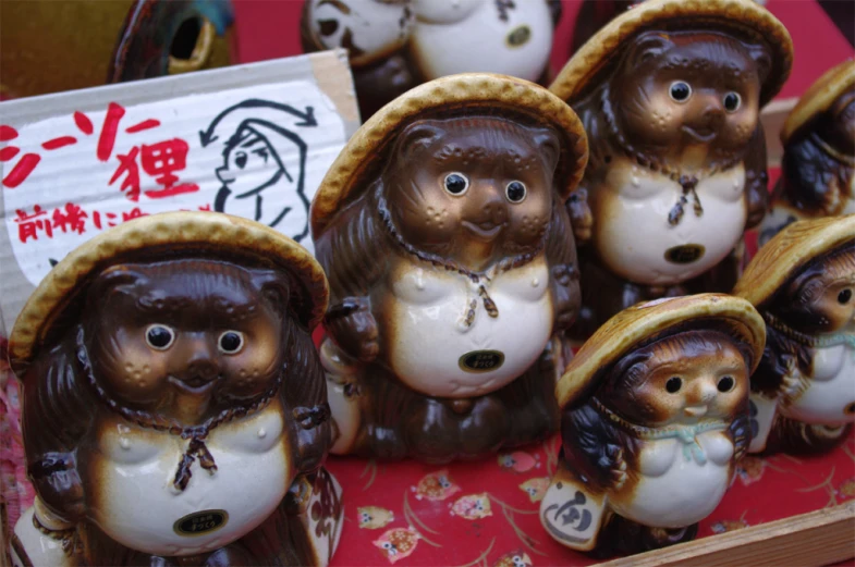 an array of little ceramic monkeys wearing hats and scarves