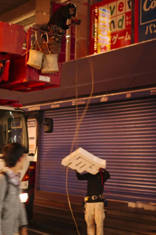 man standing in front of bus loading a box on to his head