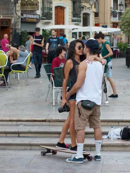 a man riding on top of a skateboard next to a woman