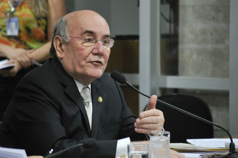 a man at a table with microphone in front of him