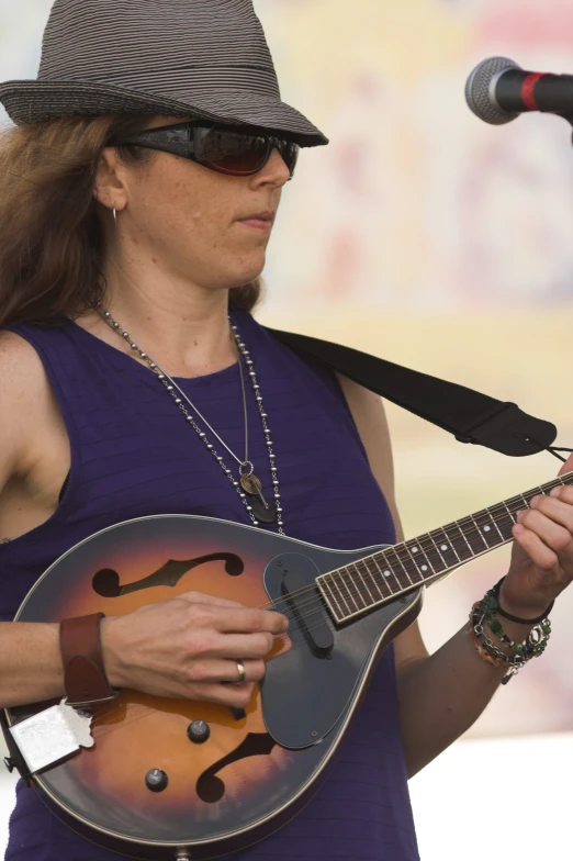 a woman holding an electric guitar standing in front of a microphone