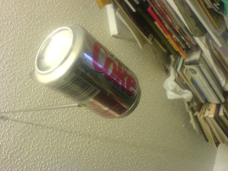 an open can of coke is hanging on the wall