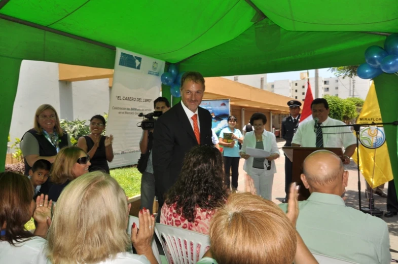 man standing in front of a crowd of people with two microphones