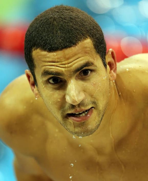 a swimmer in a pool about to get ready for his turn