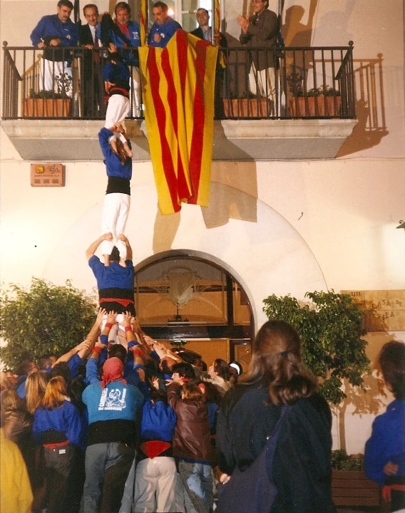 a group of people with one person on top of another while people are watching