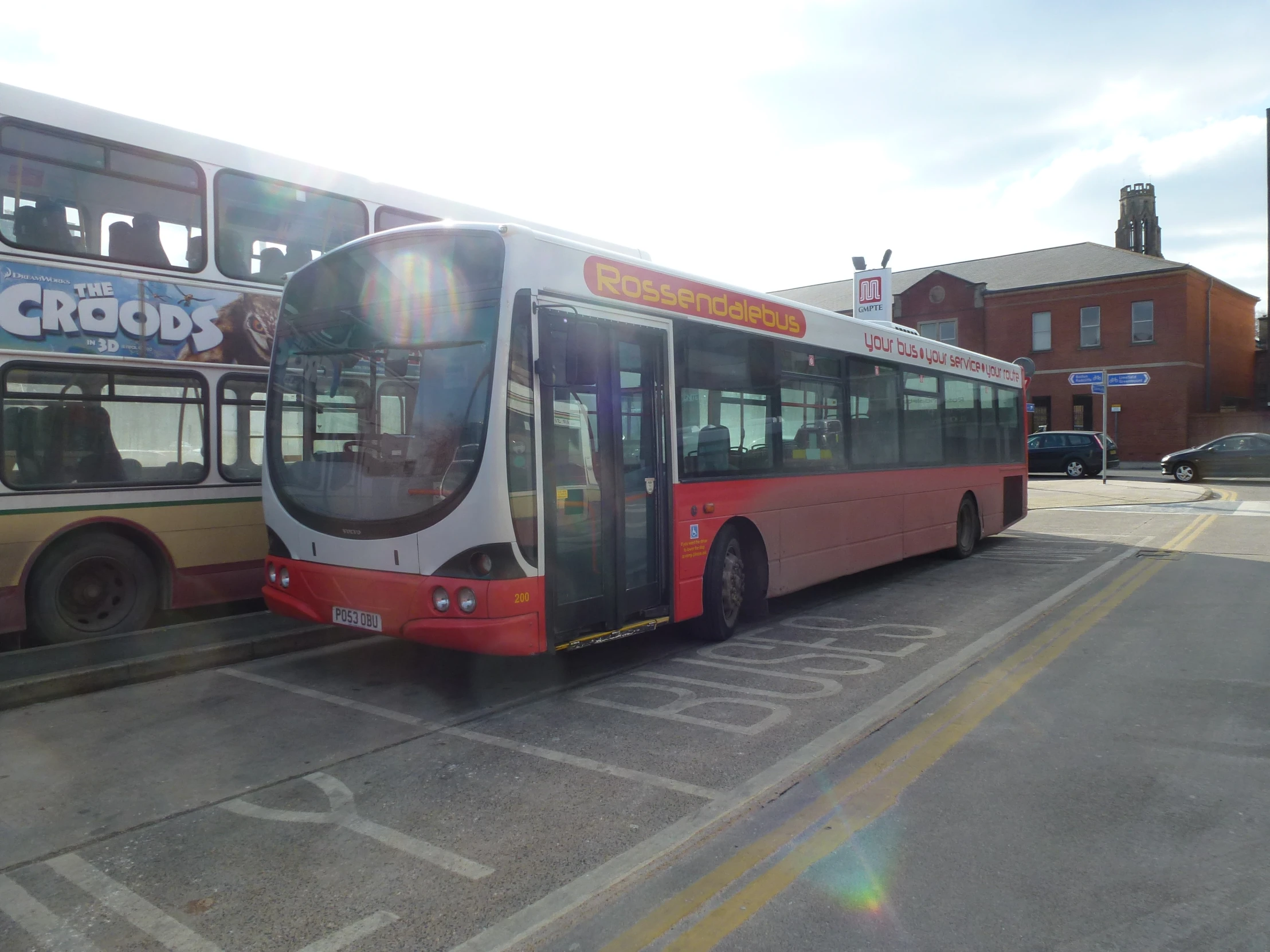 bus and vehicle parked in lot near a shopping center